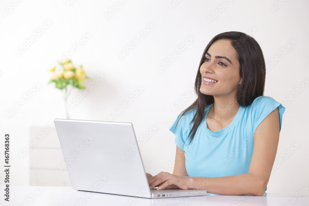 Thoughtful young woman using laptop at home Thoughtful young woman using laptop at home