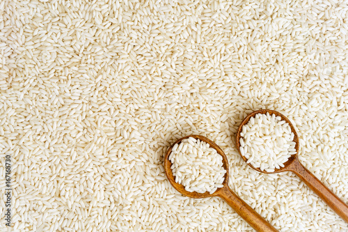 Organic sticky rice or glutinous rice with wooden spoon for background