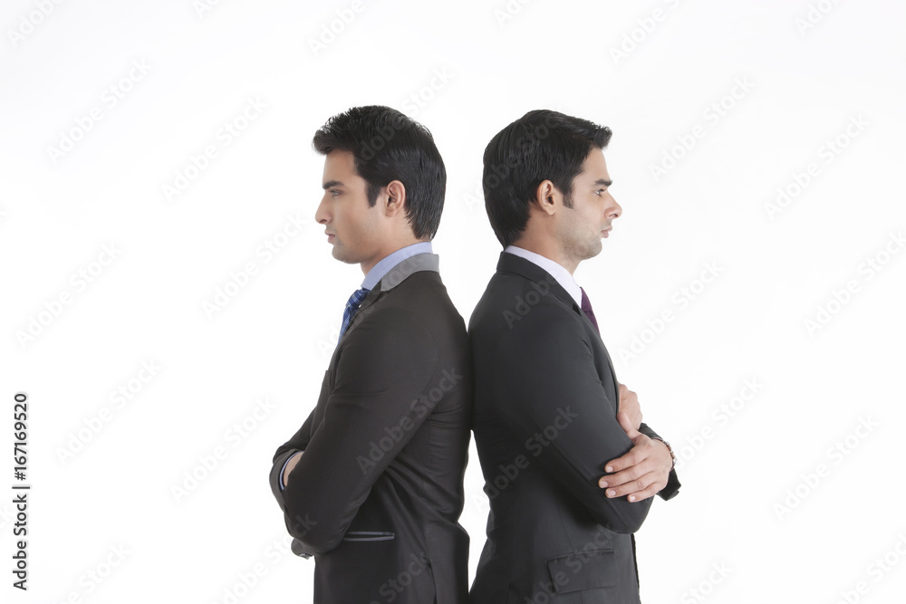 Two businessmen standing back to back Two businessmen standing back to back