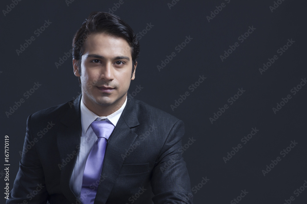 Portrait of confident businessman over black background