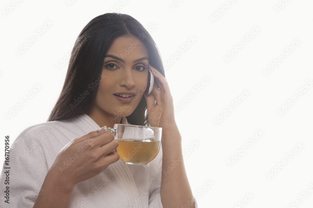 Portrait of young woman holding tea cup while using mobile phone Portrait of young woman holding tea cup while using mobile phone