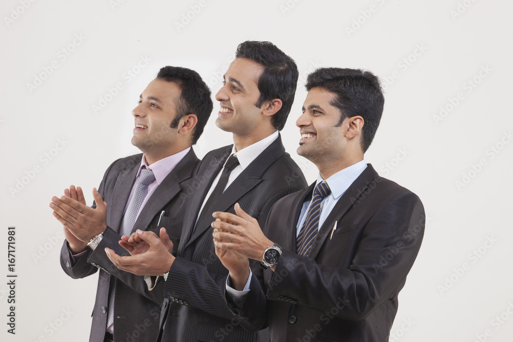 Businessmen clapping while watching cricket match Businessmen clapping while watching cricket match