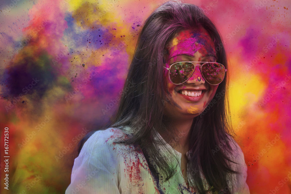 Portrait of a smiling girl with mirror sunglasses covered with colorful Gulal powder during a Holi festival Portrait of a smiling girl with mirror sunglasses covered with colorful Gulal powder during a Holi festival