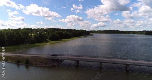 Car on a bridge, Cinema 4k aerial sideway view following cars driving over a bridge to a island, on a sunny day, in Lohjansaari, Lohja, Uusimaa, Finland photo