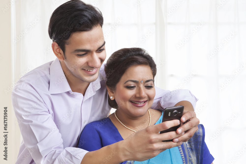 Son showing mother a picture on mobile phone