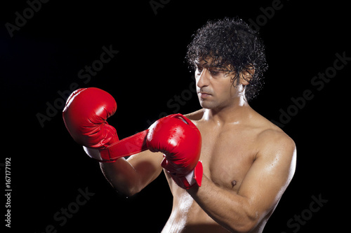Boxer wearing gloves over black background  © IndiaPix