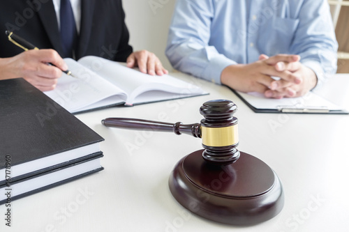 Close up of gavel, Male lawyer or judge Consult with client and working with Law books, report the case on table in modern office, Law and justice concept