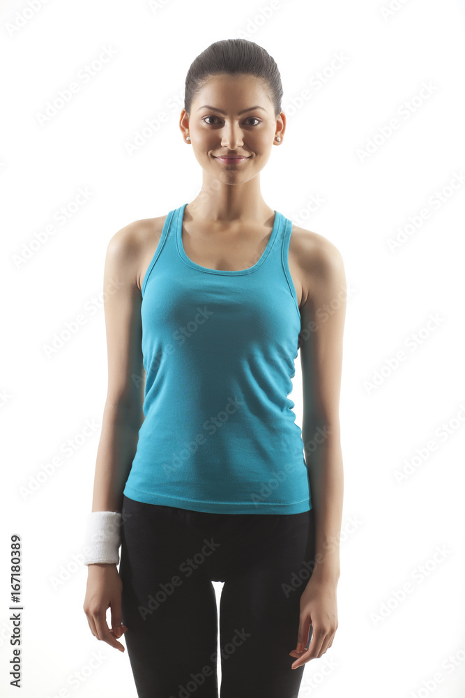 Portrait of a woman in sportswear standing against white background Portrait of a woman in sportswear standing against white background