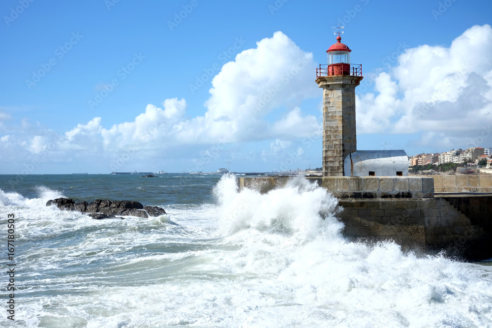 Storm waves over lighthouse in Porto, Portugal