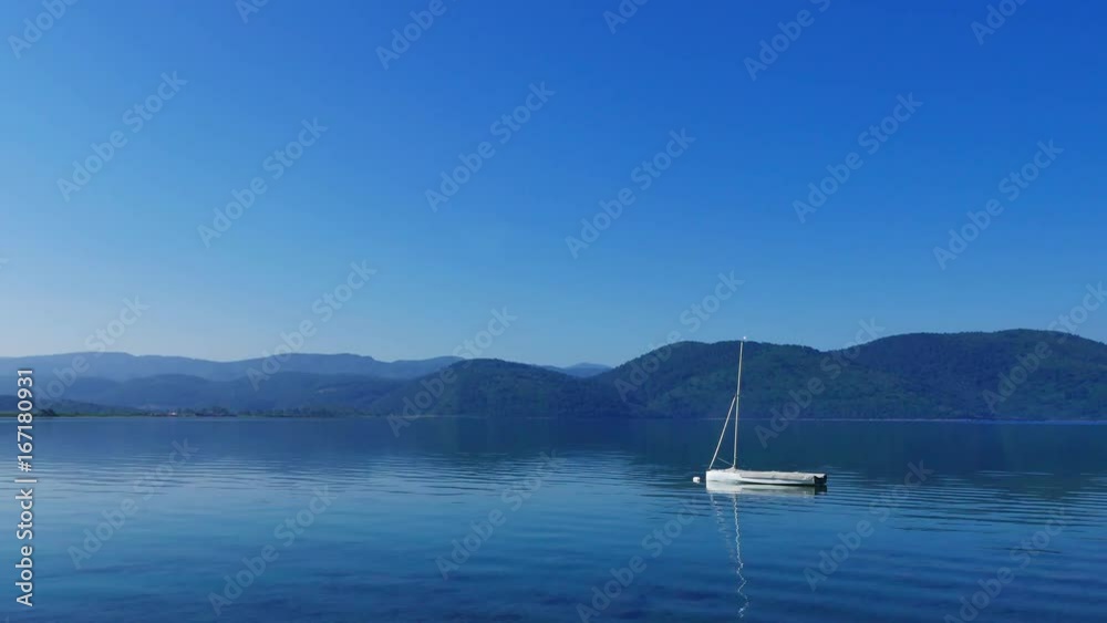 An idyllic view of Akyaka coastline (Gulf of Gokova, Mugla, Turkey) from the beach, on a quiet spring morning. A small sail boat can be seen anchored near the shore.
An idyllic view of Akyaka coastline (Gulf of Gokova, Mugla, Turkey) from the beach, on a quiet spring morning. A small sail boat can be seen anchored near the shore.