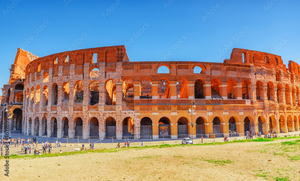 ROME, ITALY - MAY 08, 2017 : Beautiful landscape of the Colosseum in Rome- one of wonders of the world  in the morning time with tourists near him.