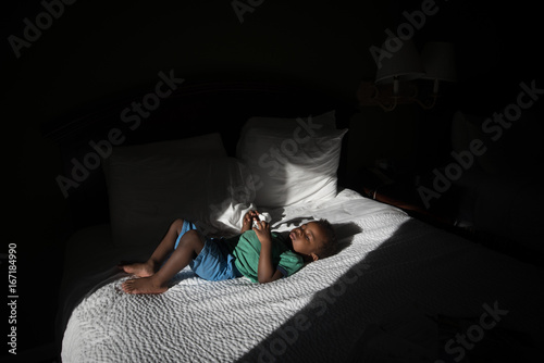 toddler boy lays in bed