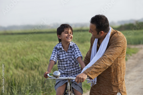 Man teaching son to ride bicycle 
