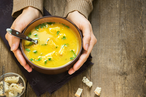 hands holding bowl of soup