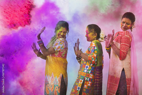 Valokuva Three Young Indian Women With Colored Face Dancing During Holi Color festival