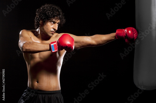 Handsome young man hitting punching bag  © IndiaPix