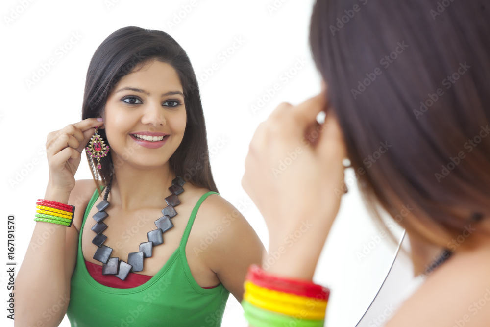 Young woman looking at herself in the mirror Young woman looking at herself in the mirror
