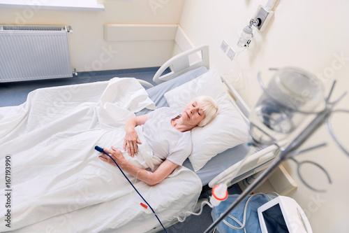 Feeble senior woman resting while recovering