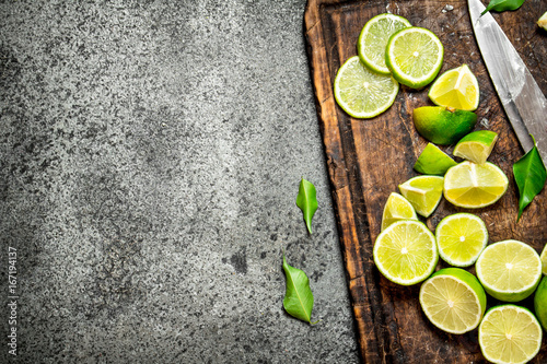 Sliced fresh limes on a cutting Board with a knife .