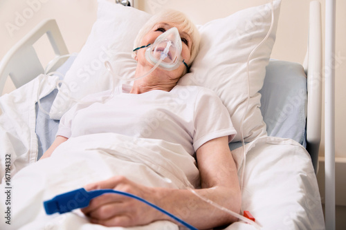 Ailing worried woman wearing life supporting devices