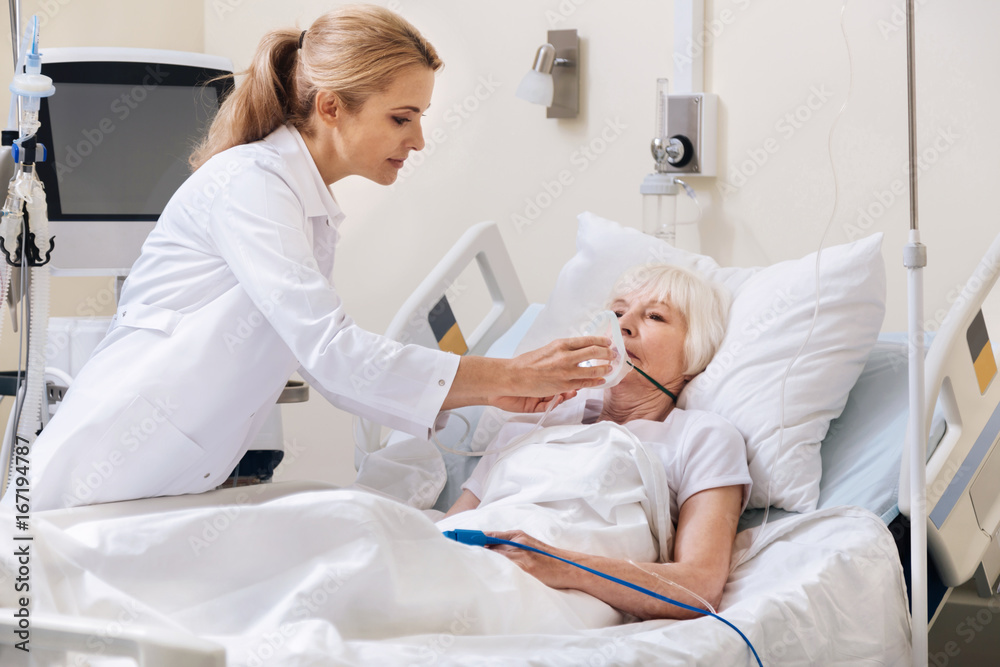 Obraz premium Determined qualified doctor using oxygen supply mask