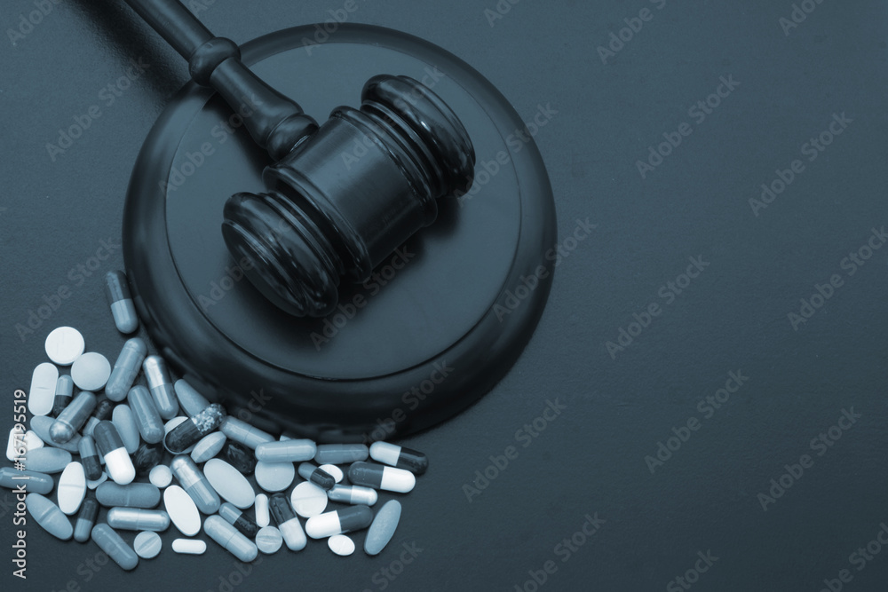 Wooden judge gavel with drugs on table with copyspace Wooden judge gavel with drugs on table with copyspace