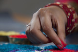 Cropped image of woman's hand making rangoli 