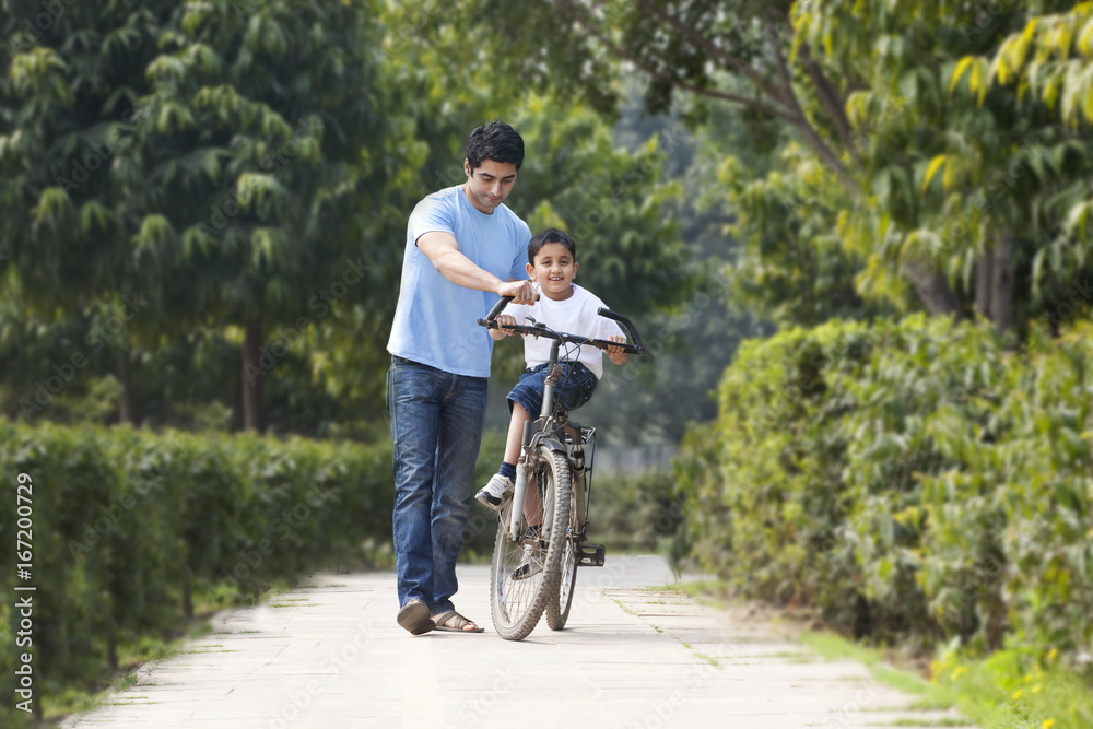 Obraz premium Father and son with a bicycle 