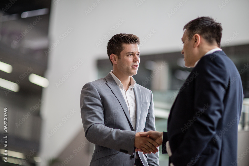 Businessmen shaking hands in a corporate office Businessmen shaking hands in a corporate office