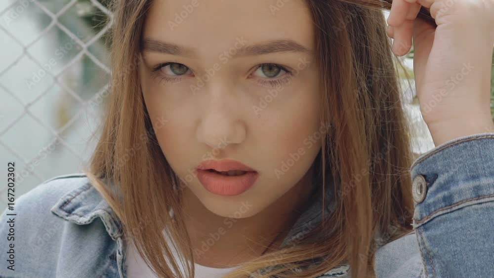 Seductive looking and posing at camera by teen female model. Slowly