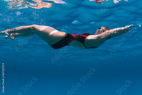 Swimmer in deep blue water of sea