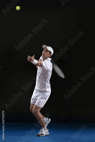 Full length of young male tennis player preparing to serve at court