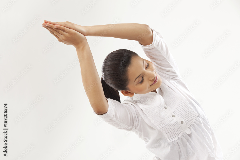 Smiling young woman with hands clasped doing yoga Smiling young woman with hands clasped doing yoga