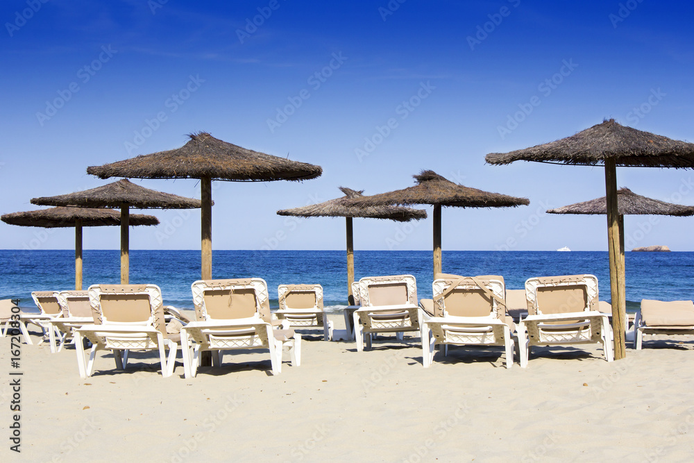 Chairs and umbrellas on a beautiful sandy beach at Ibiza