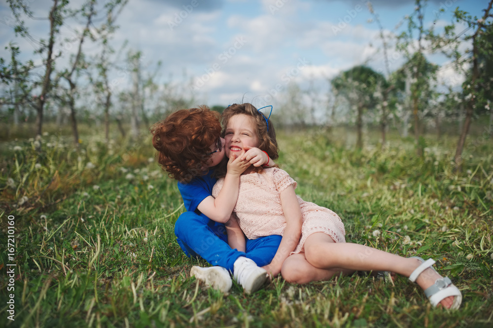 little boy and girl in blooming garden little boy and girl in blooming garden
