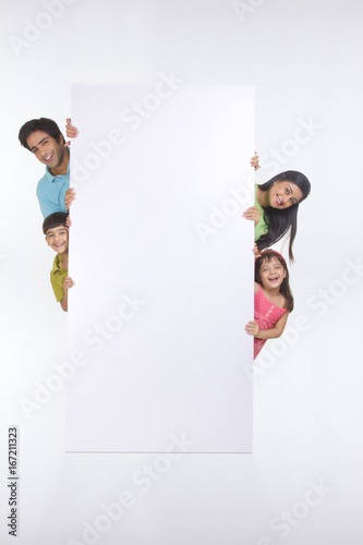 Portrait of family standing behind white board