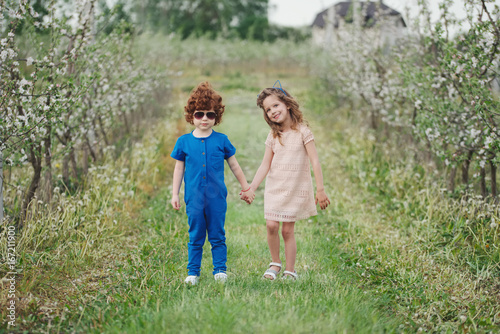 little boy and girl in blooming garden © Aliaksei Lasevich
