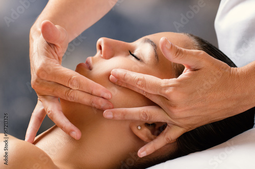Therapist massaging female face. photo