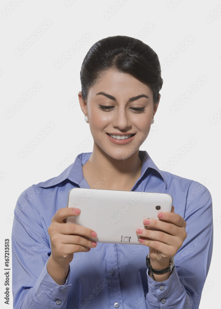 Smiling Indian businesswoman using tablet PC over white background Smiling Indian businesswoman using tablet PC over white background
