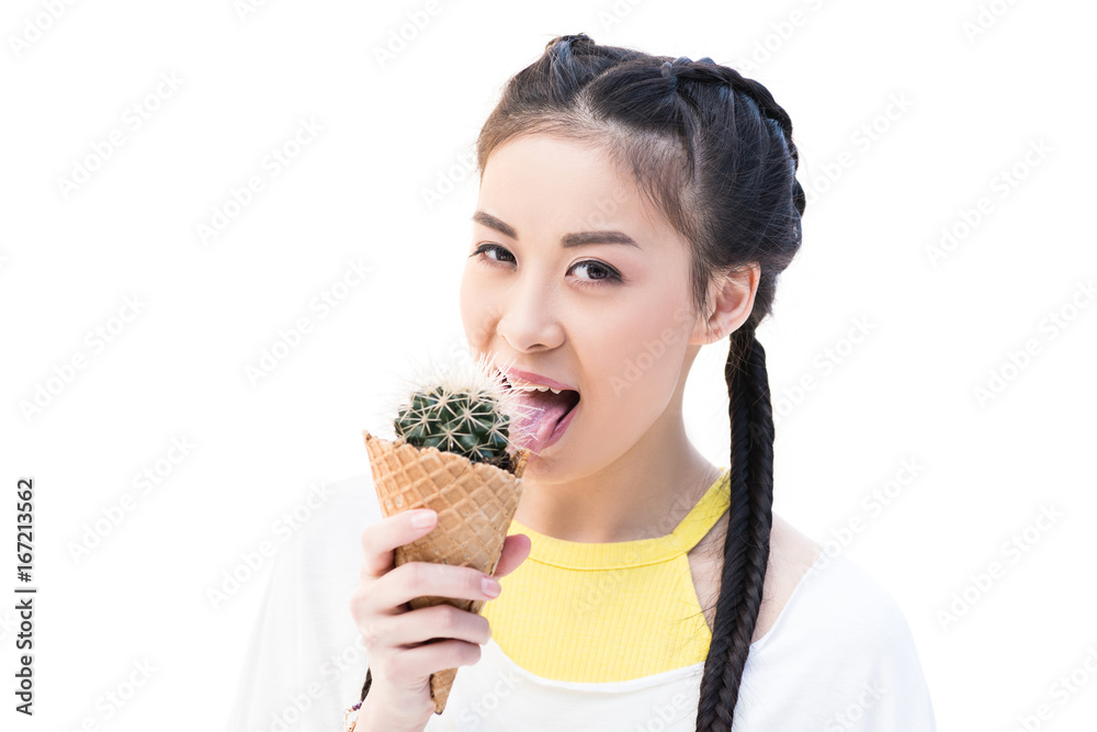 happy asian girl licking cactus in waffle cone and smiling at camera isolated on white happy asian girl licking cactus in waffle cone and smiling at camera isolated on white