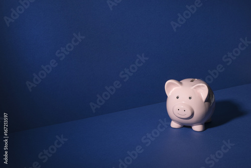 Smiling Piggy Bank Over Blue Background Copy Space