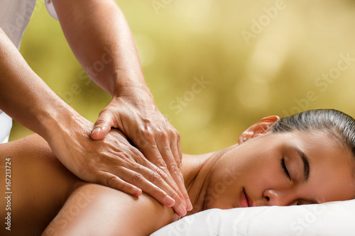 Young woman enjoying massage in spa.