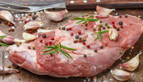 Raw lamb shoulder ready for baking with garlic, rosemary and spices. The ingredients for a delicious dinner