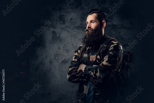 Bearded tattooed male in camouflage jacket.