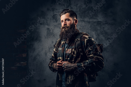 Bearded tattooed male in camouflage jacket.