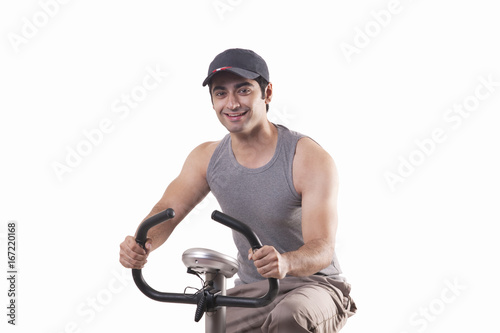 Portrait of a young man exercising over white background 