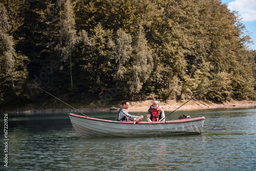 Men fishing in a calm lake from boat