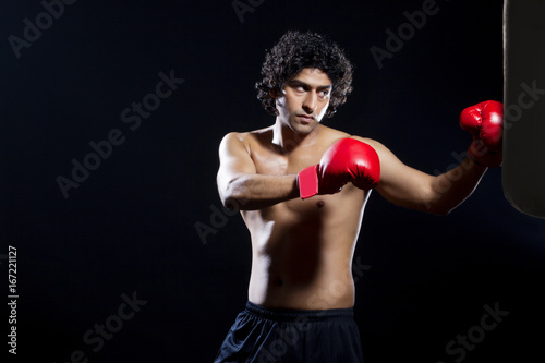 Male boxer punching the bag 