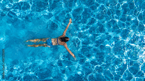 Aerial top view of woman in swimming pool water from above, tropical vacation holaday concept 