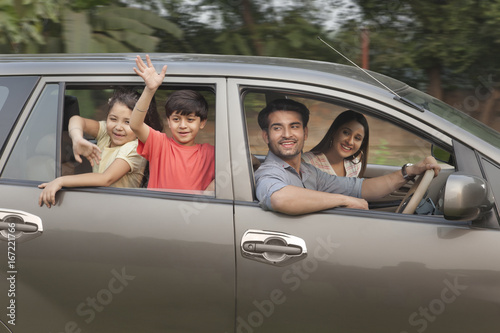 Children with parents waving from car window  © IndiaPix